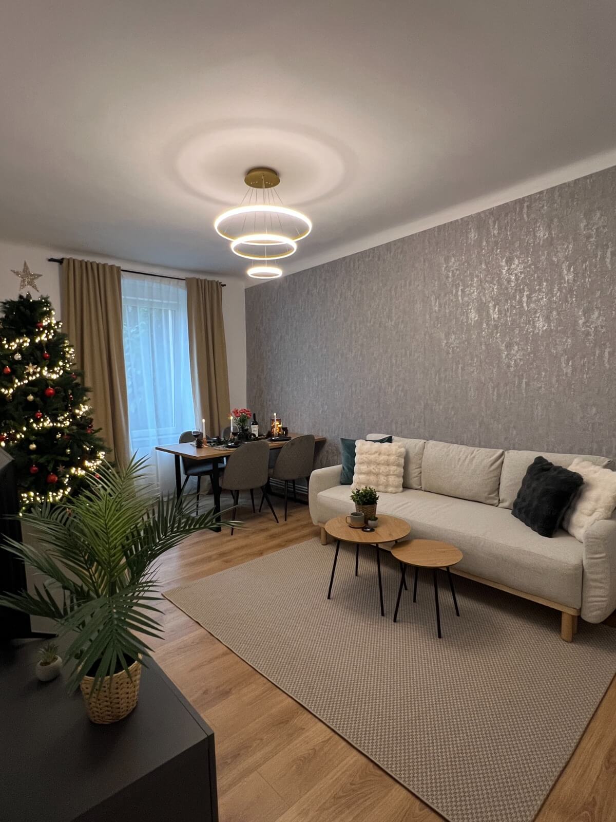 Living modern împodobit de Crăciun cu brad și lumină elegantă.