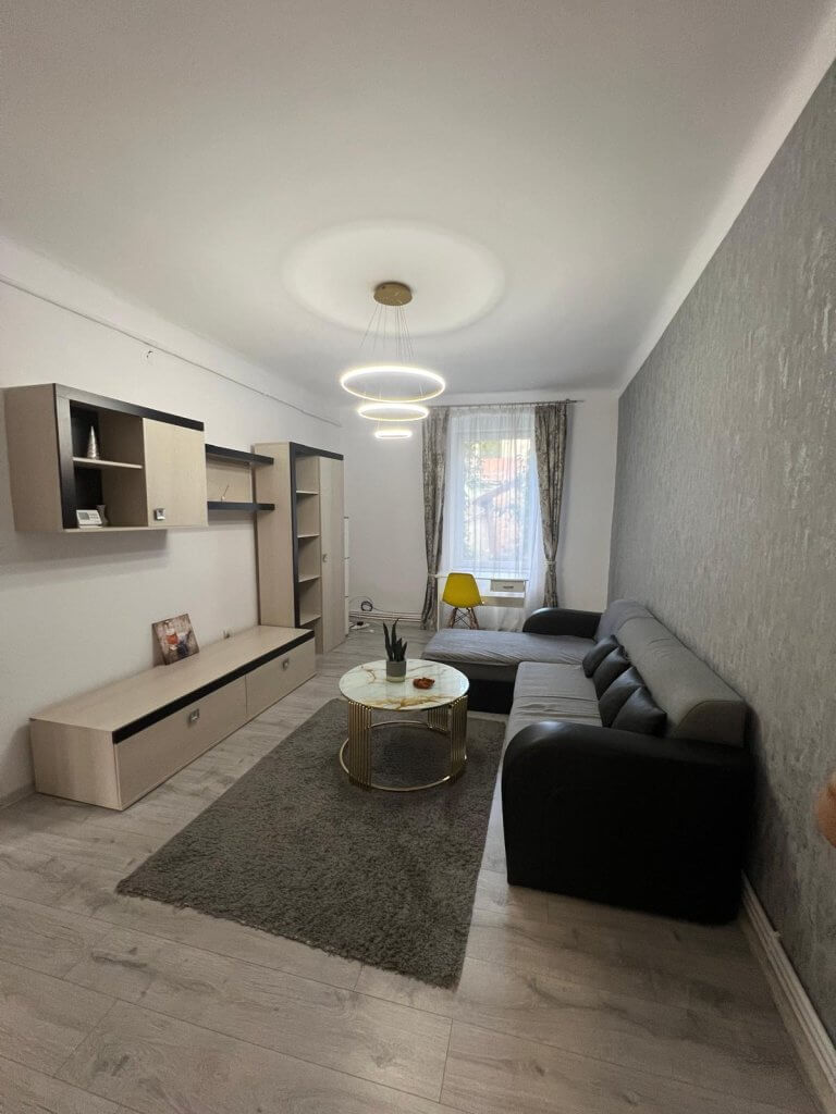 Living modern cu canapea și masă rotundă.